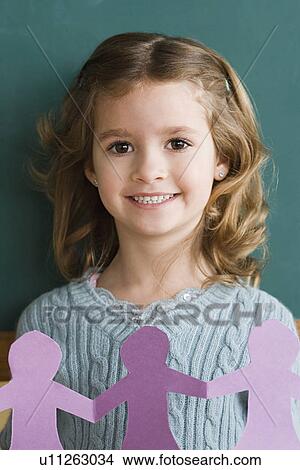 Picture - Portrait of girl (6-7) holding papercut. Fotosearch