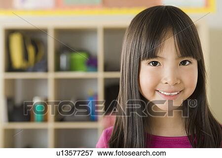Stock Photo - Portrait of girl (6-7) in school. Fotosearch