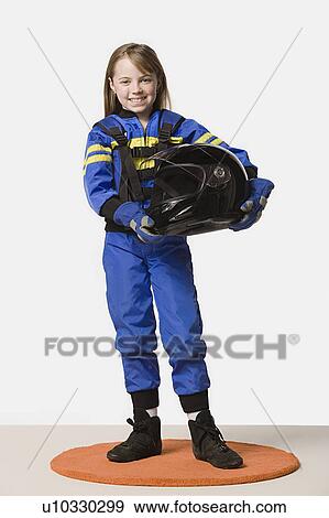 Stock Photo - Portrait of girl (8-9) dressed as racing driver, studio shot. Fotosearch