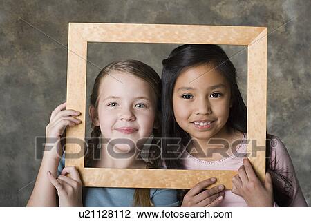 Portrait of girls (8-9) looking through picture frame, studio shot View Large Photo Image Stock Image - Portrait of girls (8-9) looking through picture frame, studio shot. Fotosearch