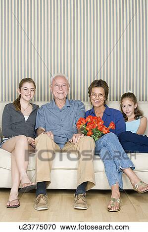 Portrait of grandparents with two granddaughters (8-9, 14-15) sitting together on sofa View Large Photo Image Stock Image - Portrait of grandparents with two granddaughters (8-9, 14-15) sitting together on sofa. Fotosearch
