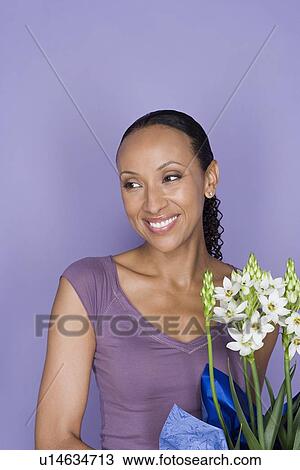 Stock Image - Portrait of happy african woman with flowers. Fotosearch