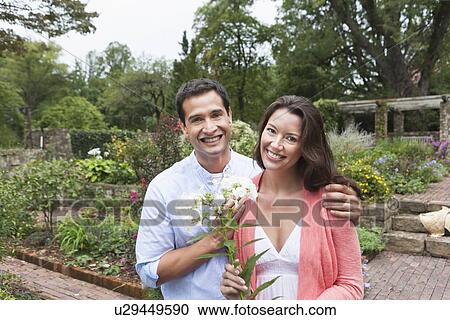 Stock Image - Portrait of happy couple in garden. Fotosearch