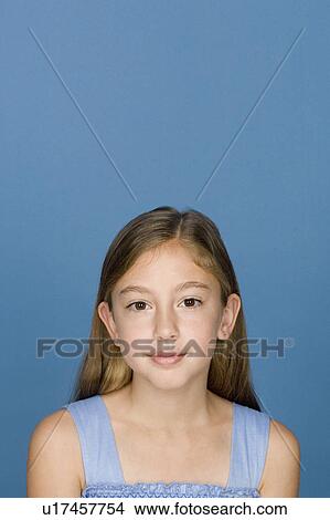 Picture - Portrait of happy girl (8-9) n blue background. Fotosearch