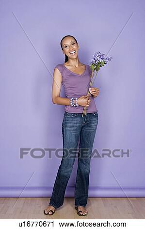Portrait of happy mid adult african woman holding flower View Large Photo Image Stock Image - Portrait of happy mid adult african woman holding flower. Fotosearch