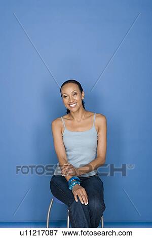 Portrait of happy mid adult african woman sitting on chair View Large Photo Image Stock Photo - Portrait of happy mid adult african woman sitting on chair. Fotosearch