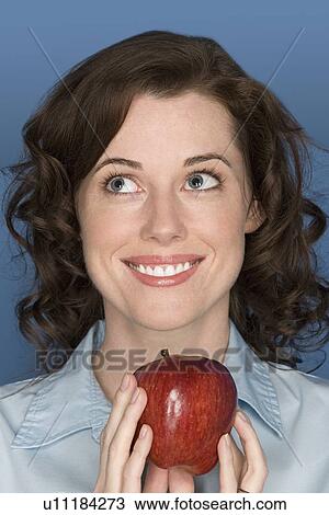Portrait of happy mid adult woman holding apple View Large Photo Image Stock Image - Portrait of happy mid adult woman holding apple. Fotosearch