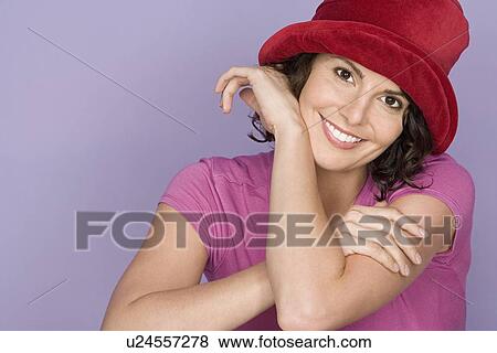 Portrait of happy mid adult woman wearing pink top and red hat View Large Photo Image Stock Photo - Portrait of happy mid adult woman wearing pink top and red hat. Fotosearch