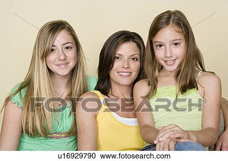 Stock Image - Portrait of happy mother with two girls (8-9, 14-15). Fotosearch