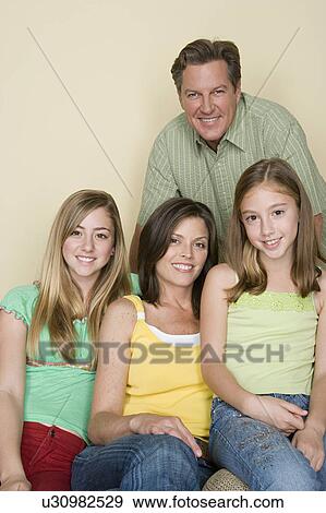 Stock Photo - Portrait of happy three-generation family with two girls (8-9, 14-15). Fotosearch