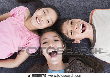 Portrait of laughing children (8-9, 10-11) lying on floor View Large Photo Image Stock Photography - Portrait of laughing children (8-9, 10-11) lying on floor. Fotosearch
