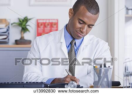 Portrait of male doctor at desk View Large Photo Image Stock Image - Portrait of male doctor at desk. Fotosearch