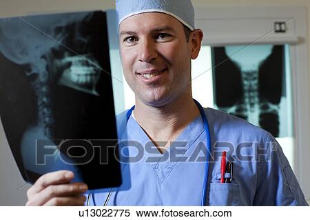 Portrait of male doctor looking at x-ray View Large Photo Image Stock Photography - Portrait of male doctor looking at x-ray. Fotosearch