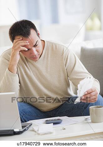 Portrait of man doing paperwork in living room View Large Photo Image Stock Photo - Portrait of man doing paperwork in living room. Fotosearch