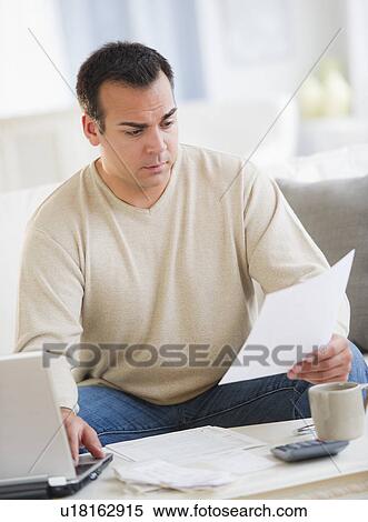 Portrait of man doing paperwork in living room View Large Photo Image Stock Photography - Portrait of man doing paperwork in living room. Fotosearch