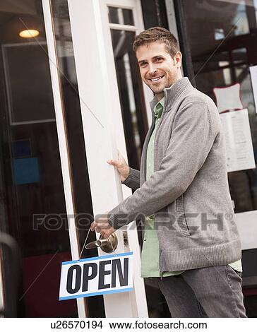 Portrait of man with 'open' sign View Large Photo Image Picture - Portrait of man with 'open' sign. Fotosearch