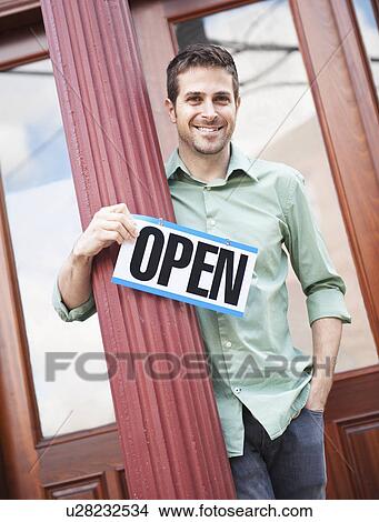 Portrait of man with 'open' sign View Large Photo Image Picture - Portrait of man with 'open' sign. Fotosearch