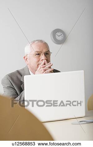 Stock Image - Portrait of mature businessman contemplating. Fotosearch