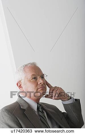 Stock Image - Portrait of mature businessman contemplating. Fotosearch