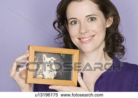 Portrait of mid adult woman holding picture of her dog View Large Photo Image Stock Photography - Portrait of mid adult woman holding picture of her dog. Fotosearch