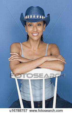 Portrait of mid adult woman sitting on white chair, wearing blue cowboy hat View Large Photo Image Stock Photo - Portrait of mid adult woman sitting on white chair, wearing blue cowboy hat. Fotosearch
