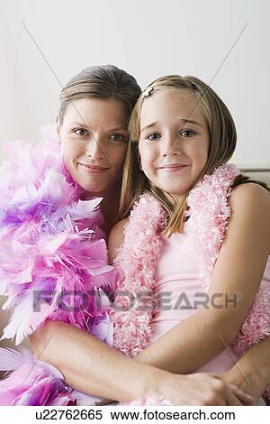 Portrait of mother and daughter (10-11) wearing feather boa at slumber party View Large Photo Image Stock Photography - Portrait of mother and daughter (10-11) wearing feather boa at slumber party. Fotosearch