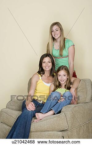 Stock Photo - Portrait of mother with two daughters (8-9, 14-15). Fotosearch