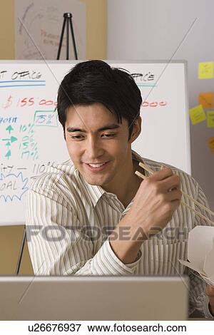 Stock Photo - Portrait of office worker with take-away food. Fotosearch
