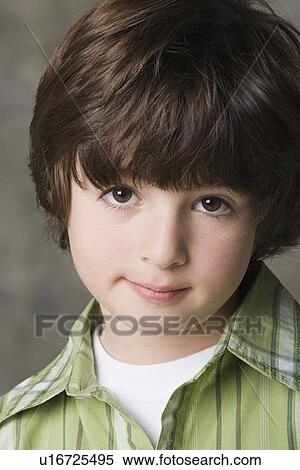 Stock Photography - Portrait of smiling (6-7) boy, studio shot. Fotosearch