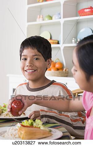 Portrait of smiling boy (10-11) and girl (8-9) dining at table View Large Photo Image Stock Photo - Portrait of smiling boy (10-11) and girl (8-9) dining at table. Fotosearch