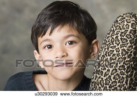 Stock Photo - Portrait of smiling boy (8-9) looking at camera, studio shot. Fotosearch