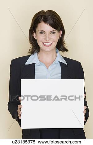 Portrait of smiling businesswoman holding blank page, studio shot View Large Photo Image Stock Photography - Portrait of smiling businesswoman holding blank page, studio shot. Fotosearch