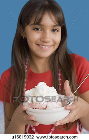 Portrait of smiling girl (10-11) holding dessert View Large Photo Image Stock Image - Portrait of smiling girl (10-11) holding dessert. Fotosearch