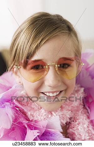 Stock Image - Portrait of smiling girl (10-11) wearing feather boa and sunglasses. Fotosearch