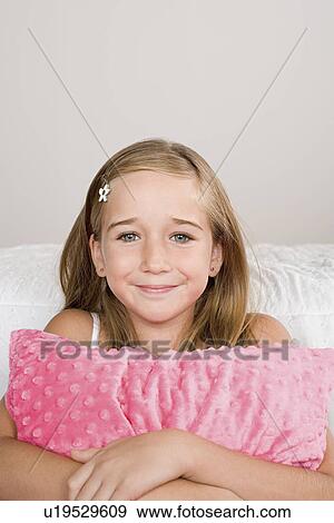 Portrait of smiling girl (10-11) with pillow View Large Photo Image Stock Photo - Portrait of smiling girl (10-11) with pillow. Fotosearch