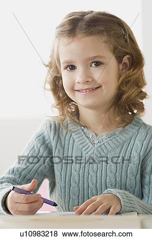 Stock Photo - Portrait of smiling girl (6-7) drawing. Fotosearch