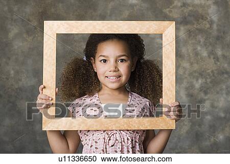 Portrait of smiling girl (8-9) holding picture frame, studio shot View Large Photo Image Stock Image - Portrait of smiling girl (8-9) holding picture frame, studio shot. Fotosearch