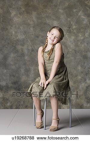 Portrait of smiling girl (8-9) sitting on stool, studio shot View Large Photo Image Stock Photo - Portrait of smiling girl (8-9) sitting on stool, studio shot. Fotosearch