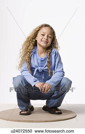Portrait of smiling girl (8-9 crouching), studio shot View Large Photo Image Stock Image - Portrait of smiling girl (8-9 crouching), studio shot. Fotosearch