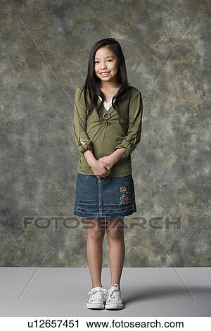 Stock Image - Portrait of smiling girl (8-9), studio shot. Fotosearch