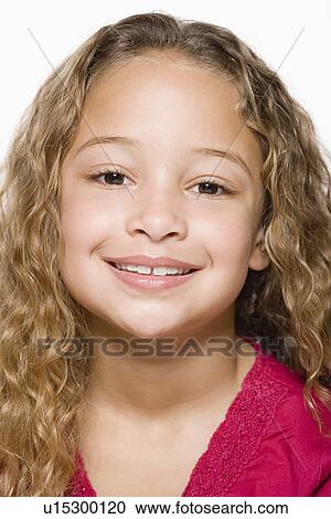 Stock Image - Portrait of smiling girl (8-9), studio shot. Fotosearch