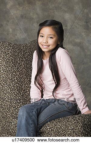 Stock Image - Portrait of smiling girl (8-9), studio shot. Fotosearch