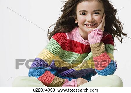 Stock Image - Portrait of smiling girl (8-9), studio shot. Fotosearch