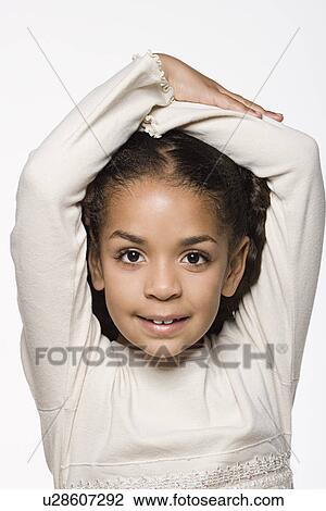 Stock Image - Portrait of smiling girl (8-9), studio shot. Fotosearch
