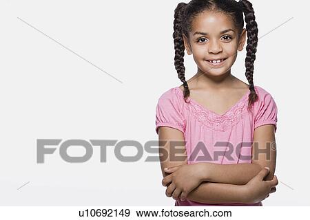 Stock Photo - Portrait of smiling girl (8-9) with braids, studio shot. Fotosearch