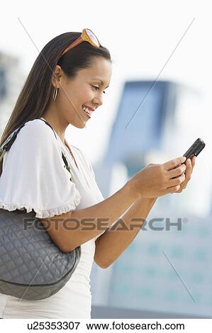 Portrait of smiling woman using mobile phone View Large Photo Image Stock Photo - Portrait of smiling woman using mobile phone. Fotosearch