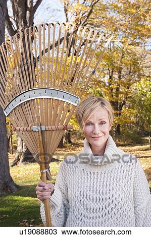 Portrait of smiling woman with rake View Large Photo Image Stock Image - Portrait of smiling woman with rake. Fotosearch