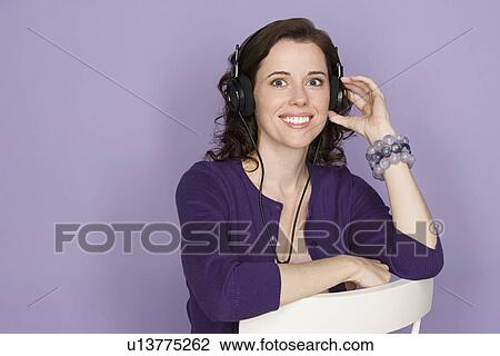 Portrait of smiling woman with headphones on purple background, studio shot View Large Photo Image Stock Image - Portrait of smiling woman with headphones on purple background, studio shot. Fotosearch