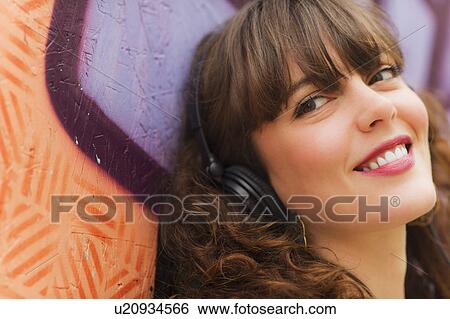 Stock Photograph - Portrait of smiling woman with headphones. Fotosearch