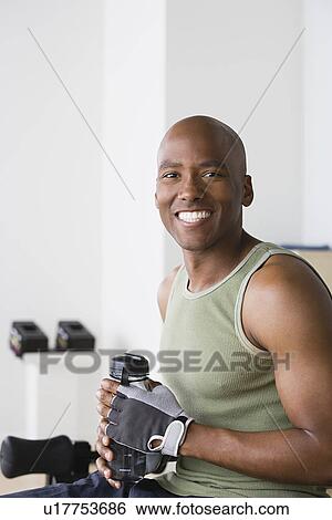 Stock Photograph - Portrait of smiling young man in gym. Fotosearch